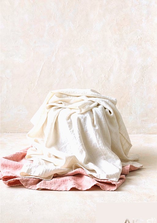 A soft pile of blush and ivory linen